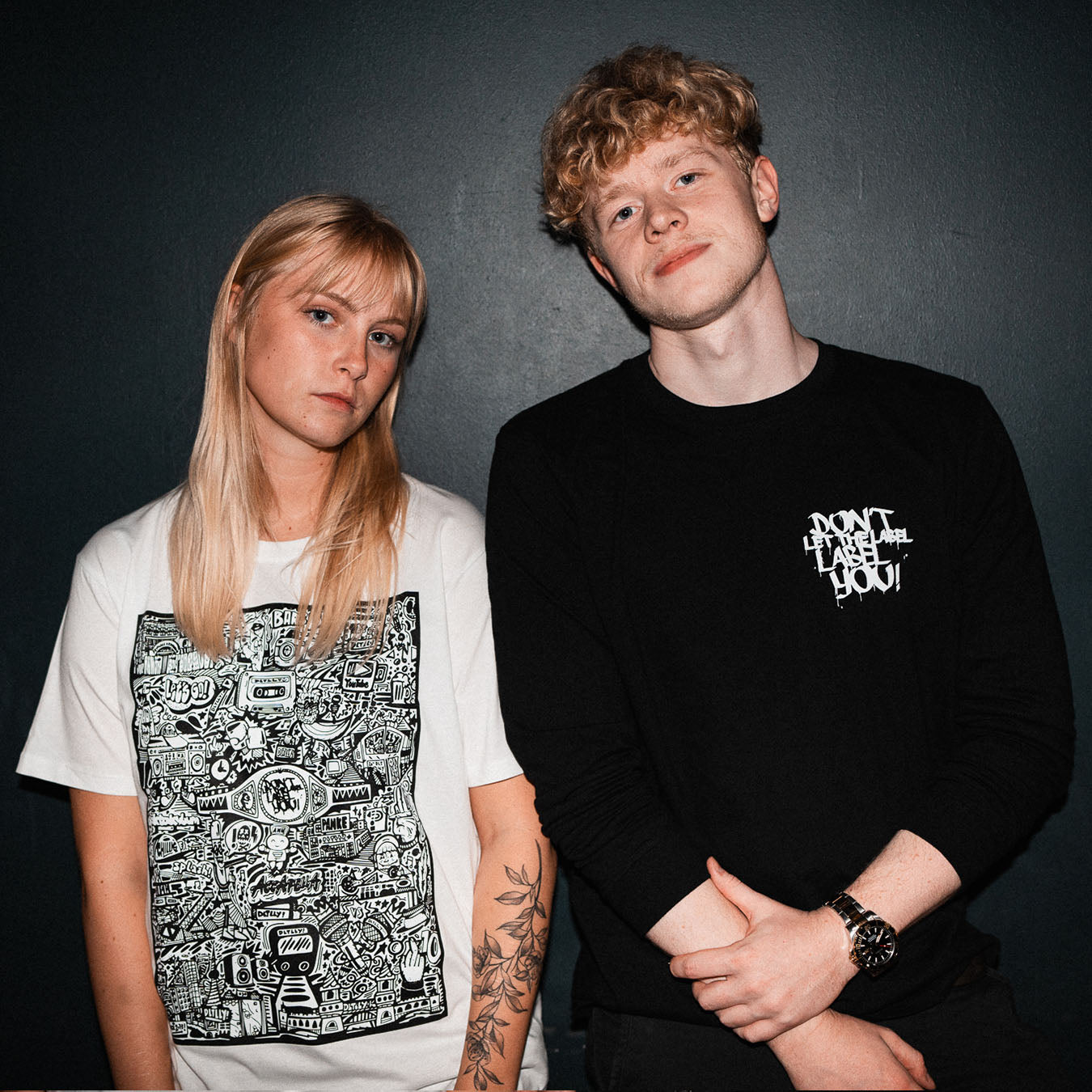 Blonder Mann und blonde Frau in Merch der Battlerap-Event-Veranstalter DLTLLY